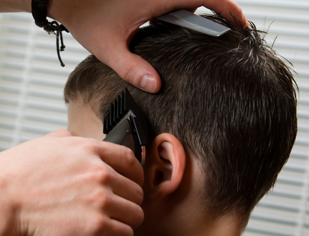 the hairdresser does the hairstyle for the boy, the clipperの写真素材