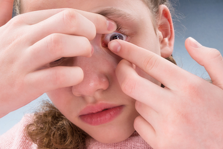 girl wears contact lenses for vision correction, close-upの写真素材