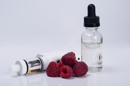 on a light background, a white e-cigarette with the aroma of liquid, for refueling with the taste of...