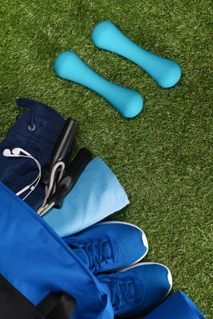 on the background of a green lawn, a set of sports things in a bag for aerobicsの写真素材