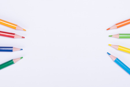 on the edges lie multicolored pencils, on a white background, with a place for an inscriptionの写真素材