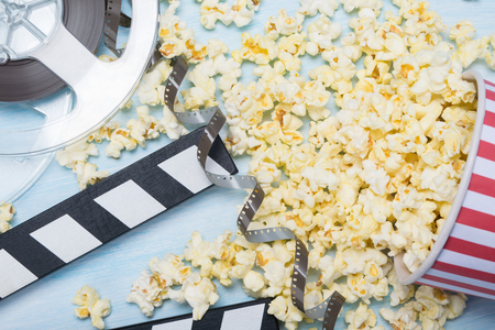 scattered paper cup popcorn with film, concept on blue backgroundの写真素材