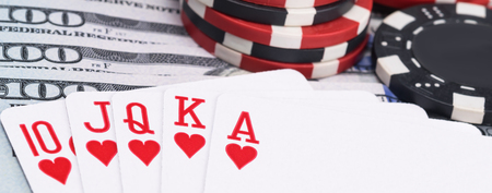 royal flush and poker chips are on the background of one hundred dollar bills, long photo
