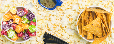 on the background of popcorn two cups with colored caramel cornの写真素材