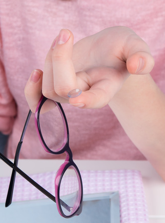 girl's hand, close-up, with contact lens, to improve vision and glassesの写真素材