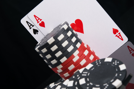 two aces and a stack of chips to play in the casino, standing on a black background