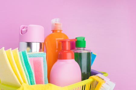 set of liquid cleaning products and items for cleaning indoors on a pink background close-upの写真素材