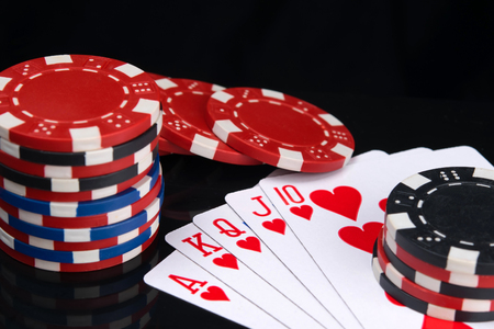 on a black background with a reflection, close-up,is a high alignment of cards for poker, street and...