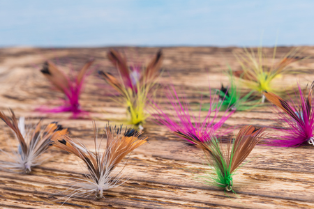 Multicolored bright bait for catching red river fareli lie on a dark burnt backgroundの写真素材