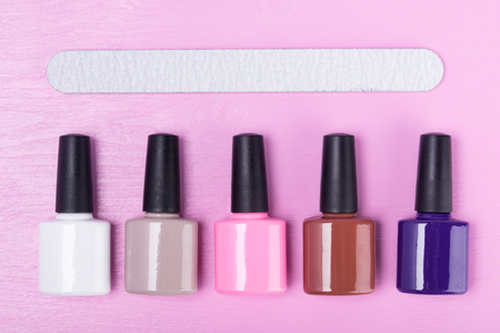 Concept for nail service: colorful nail polishes and nail file on a pink backgroundの写真素材