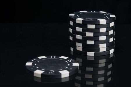 on a black background with reflection, close-up of blackjack chips