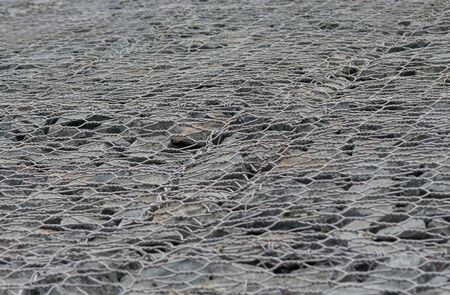 background of stones behind an iron grate, close-up