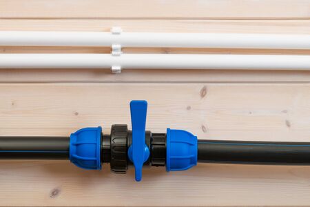 white and black water pipes on a light wooden wall
