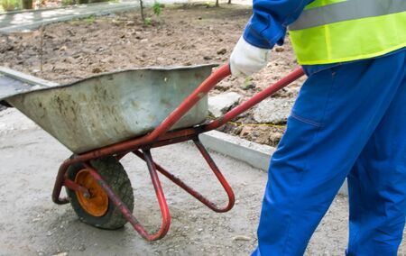 the workerâs hands in white gloves, carry a cart, on the repair section of the road, close-upの写真素材