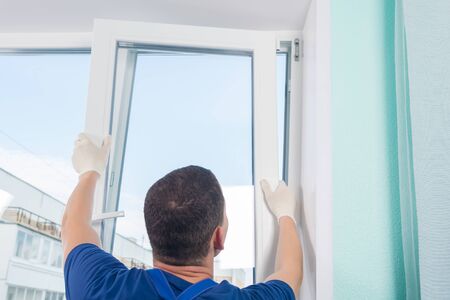 the master installs a part of the window in a new plastic frame, rear view