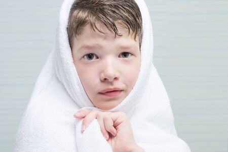 the boy wrapped his head in a bathing white towel after water procedures, portraitの写真素材