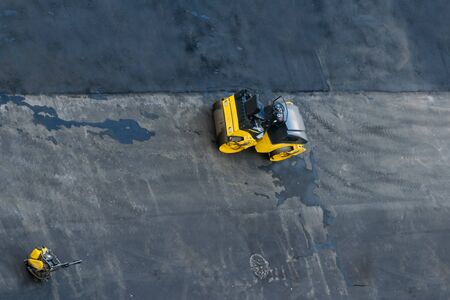 on the background of black asphalt, transport for smoothing the road, skating rink