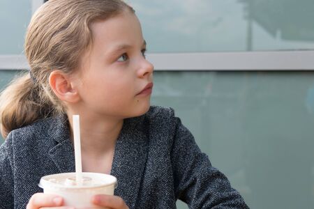 teen girl, looking at the interlocutor, portrait, holding a drink with a straw