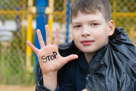 the boy wrote on his hand the inscription STOP, urging  to stop throwing, offend childrenの写真素材