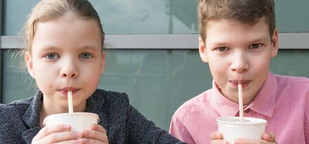 boy and girl drink milkshakes through a straw