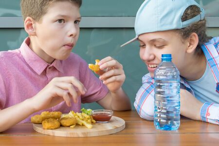 girl looks at what boy eats for lunch, front viewの写真素材