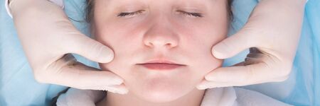 close-up, cosmetology, doctor in protective gloves doing facial massage to improve blood circulation