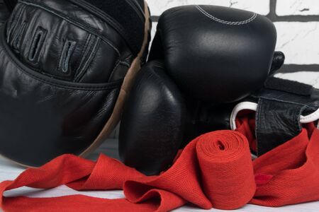 equipment and things for boxing and martial arts lies on a gray floor against a white brick wall, close-upの写真素材
