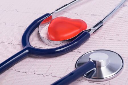 background stethoscope and red heart on research paperの写真素材