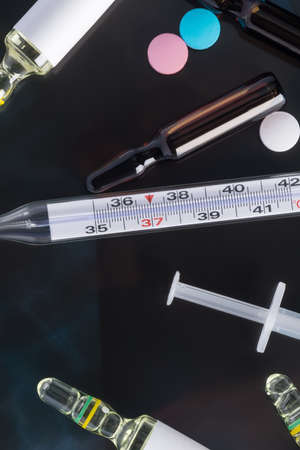 thermometer for measuring temperature and ampoules with medicine lie on x-rays, close-up