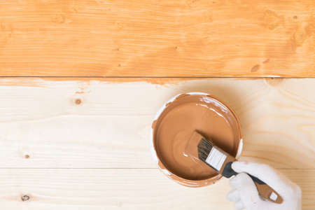 close-up, the process of impregnating a wooden floor with dark varnish manually, with a brush, there is a place for inscriptionの写真素材