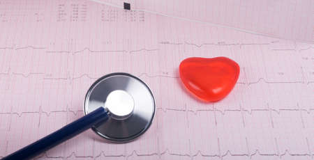 against the background of a cardiogram, phonoscope and a small red heart, close-up