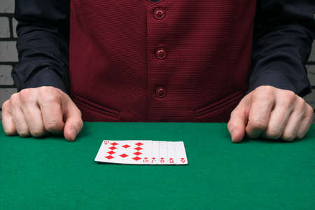 the dealer has laid out a winning poker hand on the green table