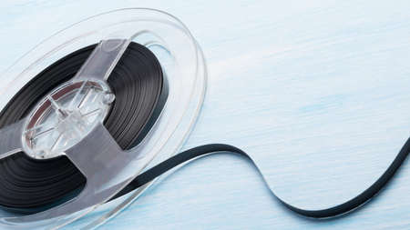 old cassette with magnetic tape on blue table backgroundの写真素材