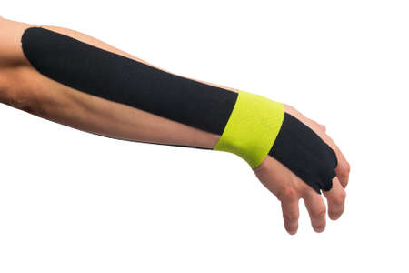 black and green medical tapes pasted on hand for pain relief, isolated on white