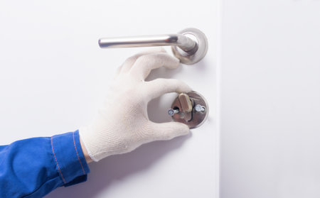 close-up, work of a locksmith in the process of repairing the door lock, view from inside the room