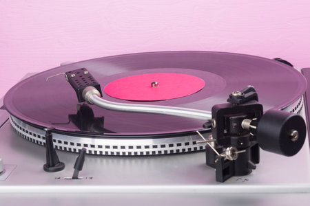 against the background of a pink wall, with a place for an inscription, an old turntable, close-upの写真素材