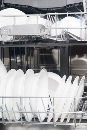 white set of dishes in dishwasher basketsの写真素材