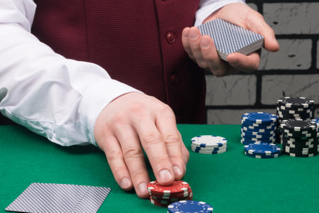 the dealer raises the bet and holds the deck of cards in his handの写真素材