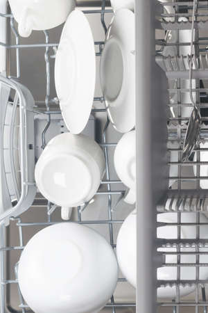 white clean dishes in the dishwasher basket top viewの写真素材
