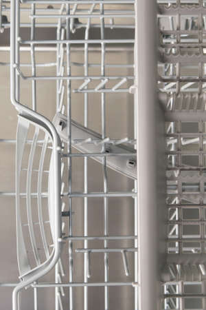 a stack of dirty dishes stands on the door of the dishwasher, front viewの写真素材