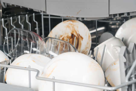 dirty white dishes and glasses in the dishwasher, close-upの写真素材