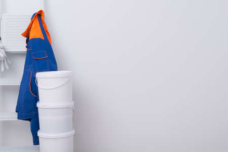three buckets of paint on top of each other, a white ladder and a protective jacket for the master, backgroundの写真素材