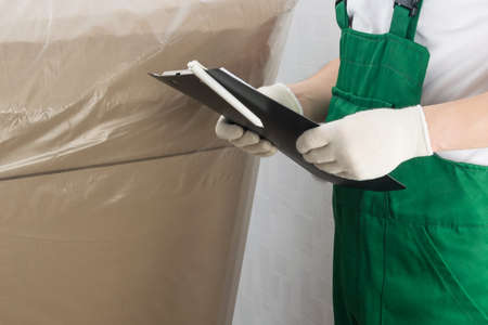 the courier checks the delivery of the goods to the address according to the documents, close-upの写真素材