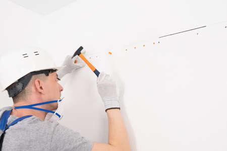 a kitchen installer attaches the hanging mechanism to the wallの写真素材
