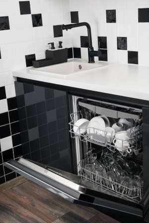 open dishwasher at the bottom of the kitchenの写真素材