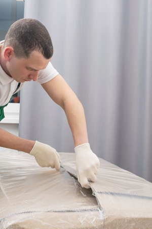 the loader opens the box with the goods at the recipient's address, close-upの写真素材