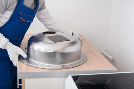 installation of a metal sink in the kitchen furniture by an assemblerの写真素材