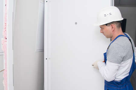 after installing the door, the master checks the correct operation of the lock and hingesの写真素材