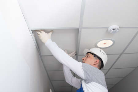 master of communications maintenance, opens the suspended ceiling, for the repair of lighting and alarm wiringの写真素材