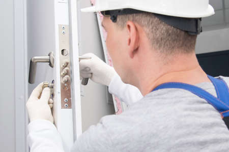 plumber, checks the correct operation, locking devices of the door lock, close-upの写真素材
